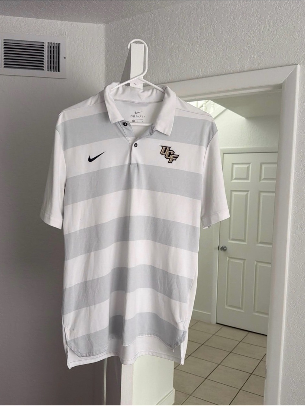 Nike Dri-Fit Men’s White and Light Gray Striped UCF Polo.